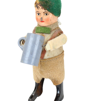Vintage-style toy figure with a green hat and brown outfit on a white background