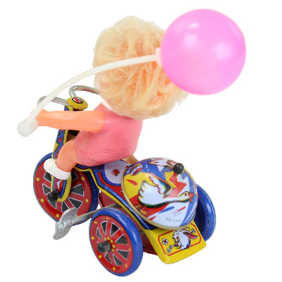 Toy figure on a colorful motorcycle with a pink balloon, on a white background