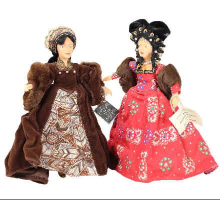 Two dolls in traditional outfits on a white background