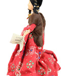Doll with a red dress featuring floral patterns on a white background