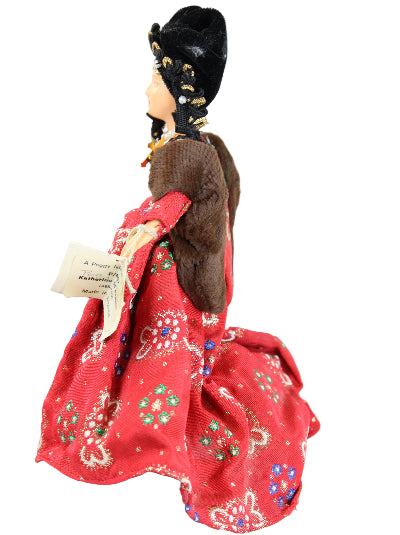 Doll with a red dress featuring floral patterns on a white background