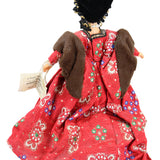 Traditional doll in a red outfit with intricate patterns on a white background