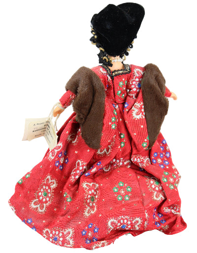 Traditional doll in a red outfit with intricate patterns on a white background