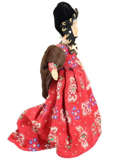 Traditional doll with a red outfit on a white background