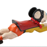 Vintage-style toy figure of a character in a top hat and red outfit on a white background