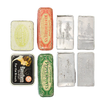 Collection of vintage tins with different designs on a white background