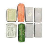 Collection of vintage small metal boxes with different designs and text on a white background