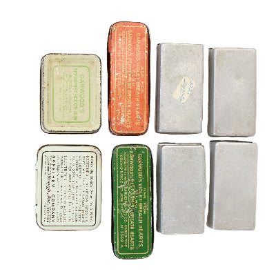 Collection of vintage small metal boxes with different designs and text on a white background