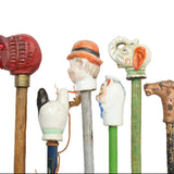 Collection of decorative walking sticks with various handles on a white background