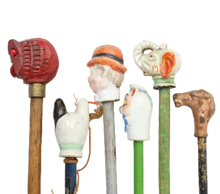 Collection of decorative walking sticks with various handles on a white background