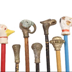 Collection of vintage walking sticks with decorative animal heads on a white background