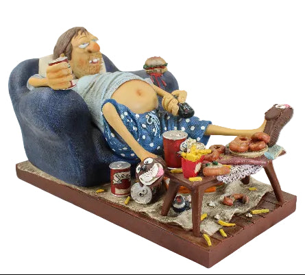 Statue of a person lounging on a couch with food and drinks, on a white background
