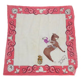 Decorative fabric square with a horse and rider design on a pink border.