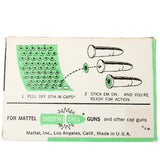Vintage packaging for Mattel cap guns with green and black design on a light gray background