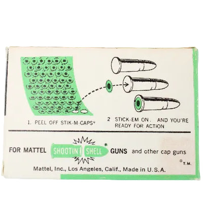 Vintage packaging for Mattel cap guns with green and black design on a light gray background