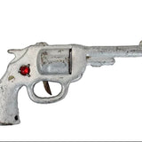 Toy revolver with a red gem on a white background