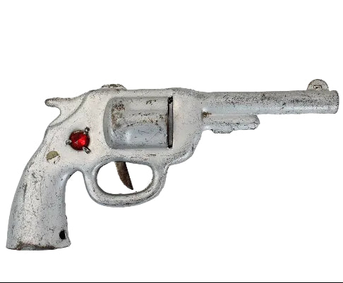 Toy revolver with a red gem on a white background