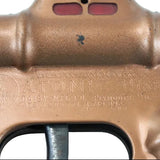 Close-up of a brass toy gun with 'Atomic Model' branding on a light blue background