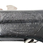 Close-up of a firearm with engraved text and a visible brand logo.
