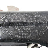 Close-up of a firearm with engraved text and a visible brand logo.
