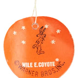 Round orange tag with a black outline of a character and 'Wile E. Coyote' text, hanging on a white background.