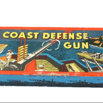 Vintage toy box labeled 'Coast Defense Gun' with colorful graphics on a white background
