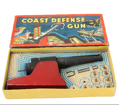 Vintage toy Coast Defense Gun in its original packaging on a white background
