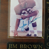 Plaque with a photo of Jim Brown and his career statistics on a wooden background