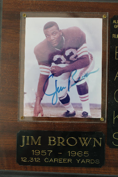 Plaque with a photo of Jim Brown and his career statistics on a wooden background