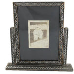 Decorative picture frame with a small photograph inside on a white background