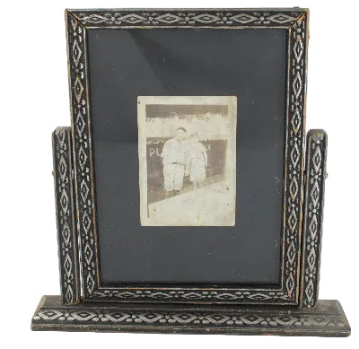 Decorative picture frame with a small photograph inside on a white background
