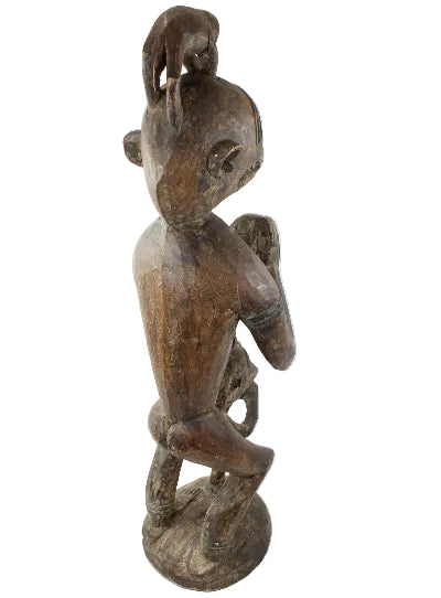 Wooden sculpture of a figure on a white background