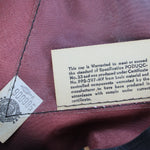 Close-up of clothing labels on a maroon fabric background