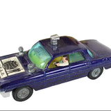Vintage toy police car with a driver figure on a white background