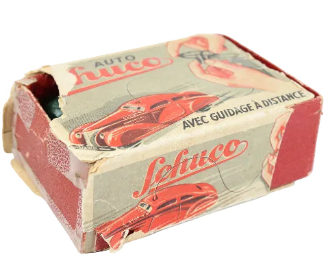 Vintage toy car packaging with 'Schuco' branding on a white background