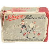 Vintage Schuco toy packaging with illustration of two figures and text on a white background