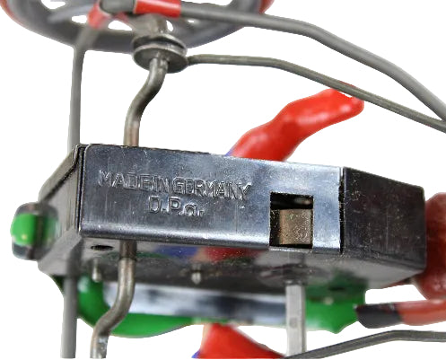Mechanical component with 'Made in Germany' label on a colorful background