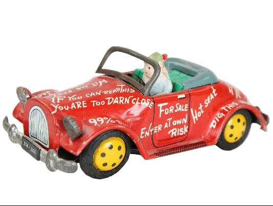 Red toy car with humorous text on a white background