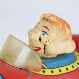 Vintage toy with Howdy Doody face and red body on a white background
