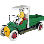 Toy model of a vintage car with a driver figure on a dark background
