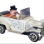 Toy car with a figure of a man in a top hat on a dark background