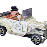 Toy car with a figure of a man in a top hat on a dark background