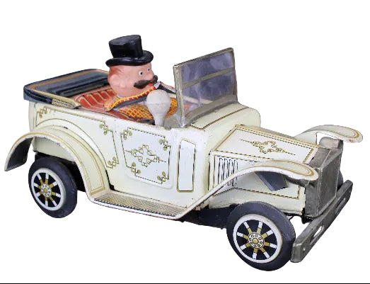 Toy car with a figure of a man in a top hat on a dark background