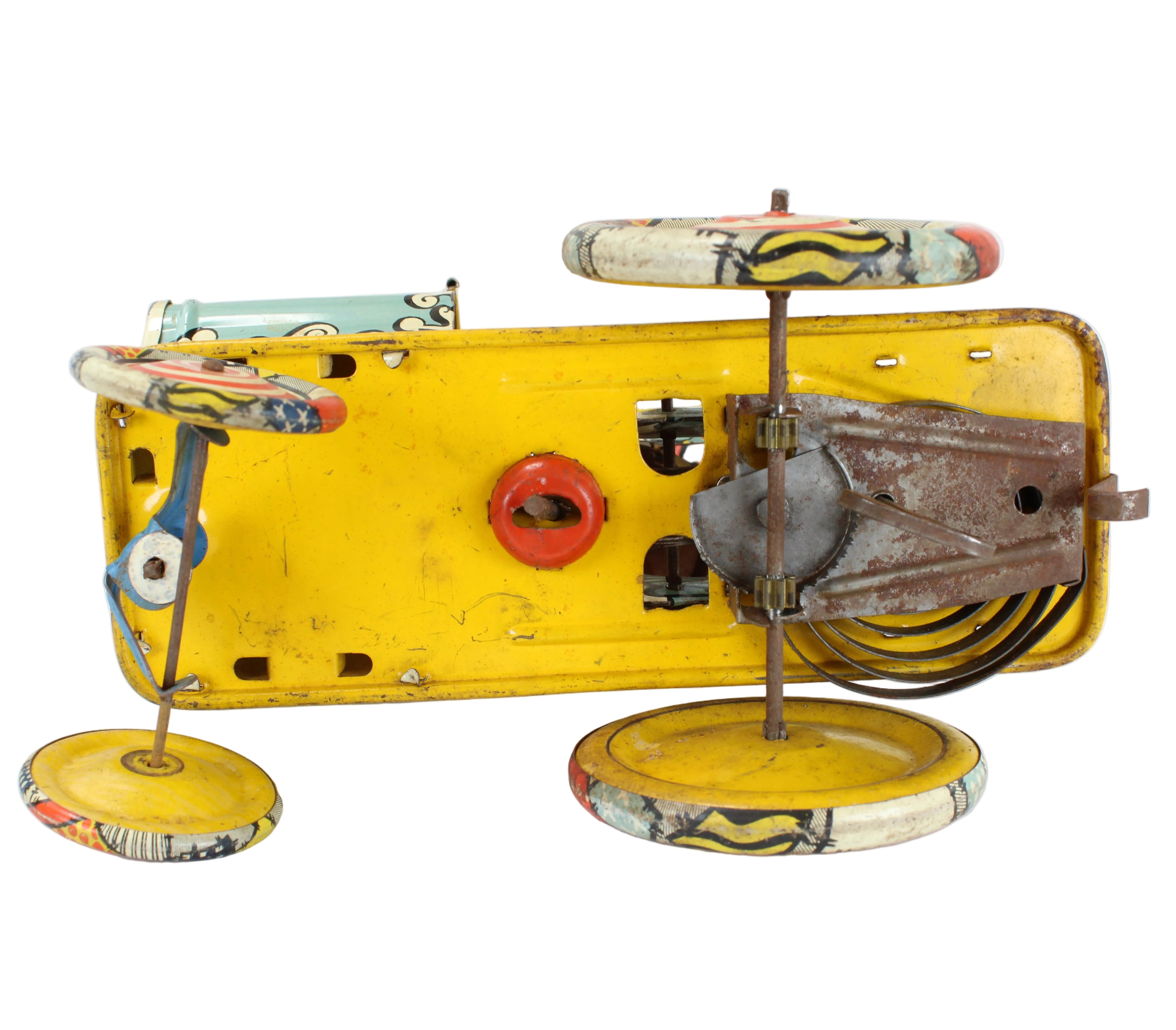 Vintage toy car with a yellow body and metal components on a white background