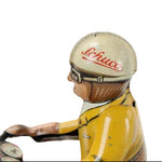Vintage tin toy figure of a driver with a helmet and Schuco logo and yellow outfit on a white background