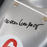 Close-up of Hans Herrmann autograph on metallic surface with signature and logo