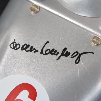 Close-up of Hans Herrmann autograph on metallic surface with signature and logo