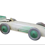 Vintage toy race car with green and white design on a dark background