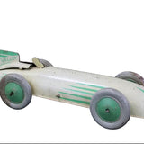 Vintage toy race car with green and white design on a dark background
