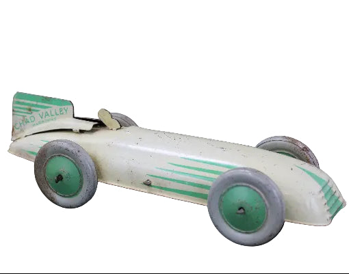 Vintage toy race car with green and white design on a dark background